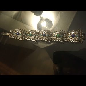 Silver colour metal bracelet with blue, green, and turquoise stones.